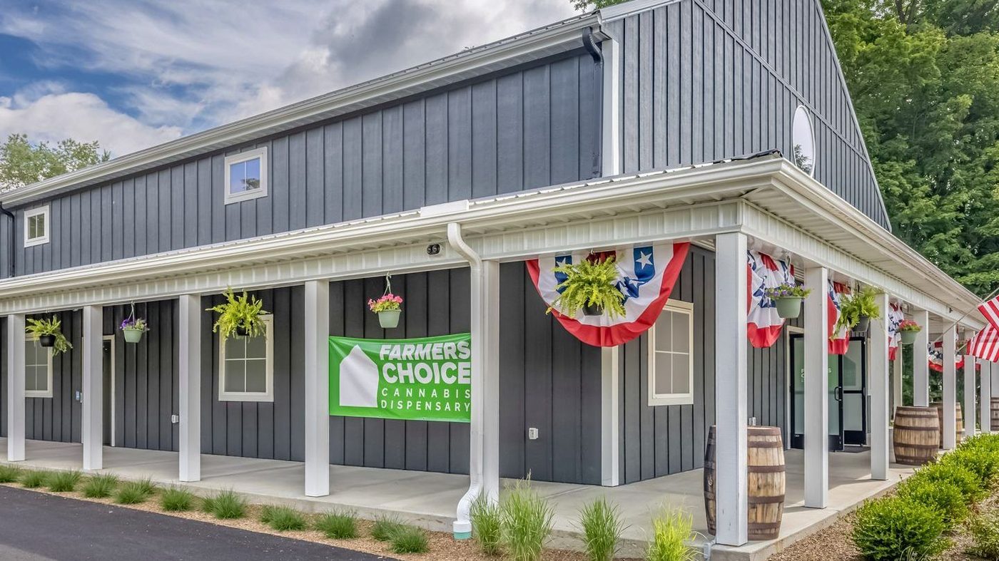 Exterior of Farmers Choice dispensary with gray siding and American flags
