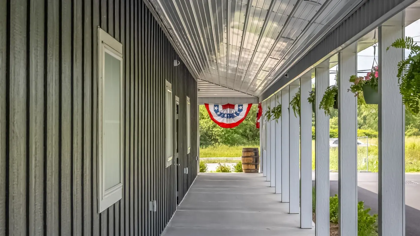 Side view of Farmers Choice dispensary porch with hanging plants and flag